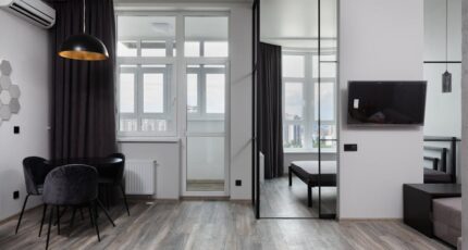 Hedendaagse kamerinterieur met stoelen onder lamp en airconditioning in licht huis met glazen wand
