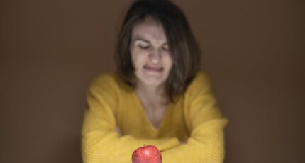 Vrouw kijkt vol afschuw naar de appel