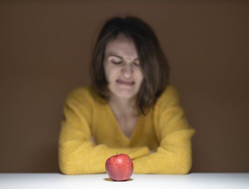 Vrouw kijkt vol afschuw naar de appel