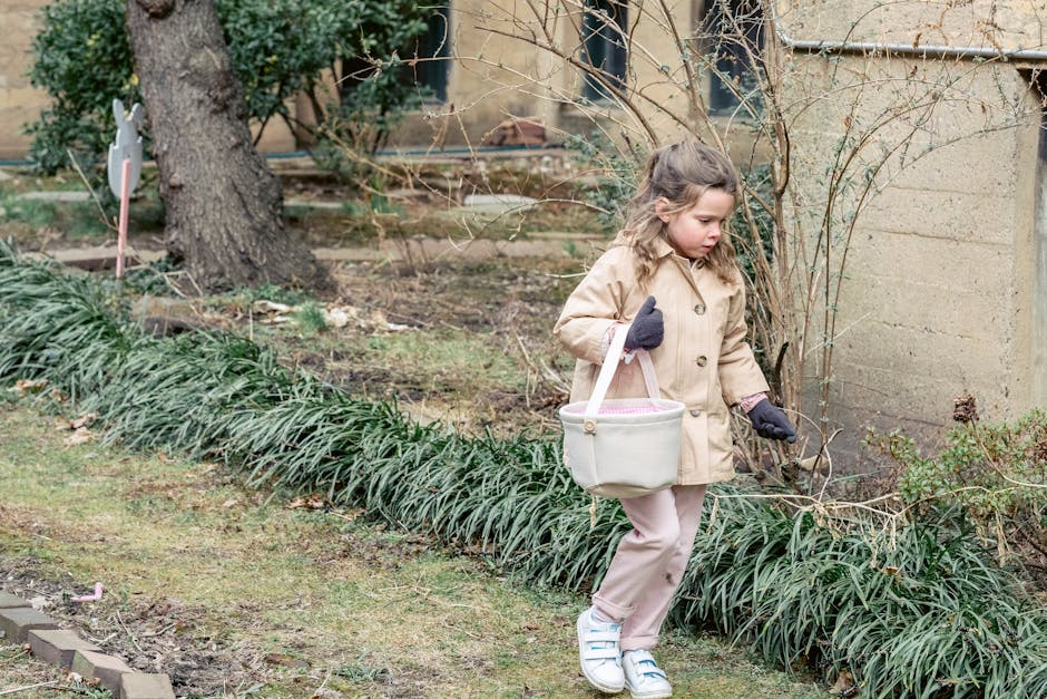 Meisje in warme kleding draagt stoffen mand en zoekt naar verstopte paaseieren terwijl ze loopt in weelderige lentetuin
