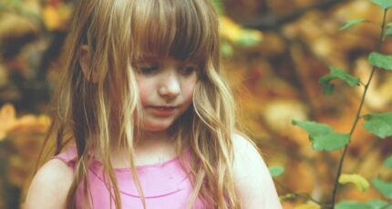 Meisje draagt een roze mouwloze jurk