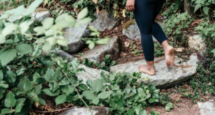 Persoon in zwarte legging die op rots loopt