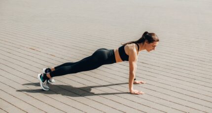 Een vrouw in sportkleding doet een push-up