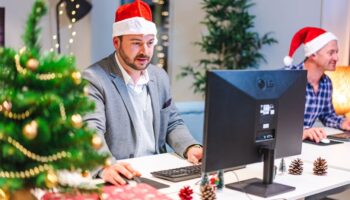 Mannen in kerstmutsen werken op kantoor