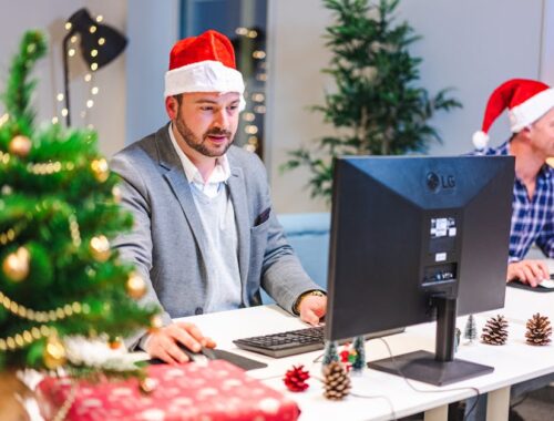 Mannen in kerstmutsen werken op kantoor