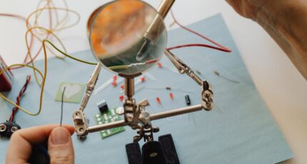 Een persoon die een soldeerbout vasthoudt.