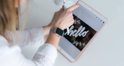 Vrouw met een Apple Watch, die een gouden iPad en een Apple Pencil vasthoudt.