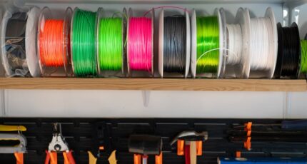 Kleurrijke 3D-printfilament op spoelen, verspreid in verschillende tinten.