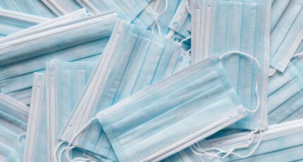 een foto van mondkapjes die op elkaar gestapeld liggen