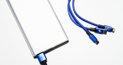 een witte powerbank met blauwe snoertjes