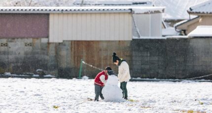 kinderen bouwen een sneeuwpop