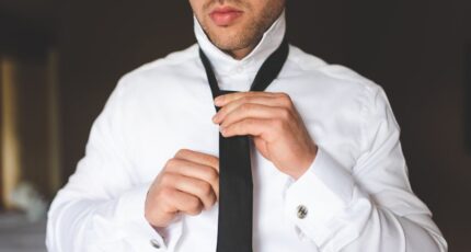 een man die een stropdas knoopt