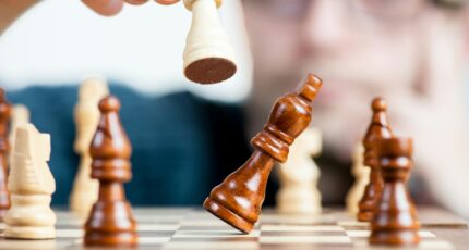 Close-up of a chess game with a focused player, emphasizing strategy and competition.
