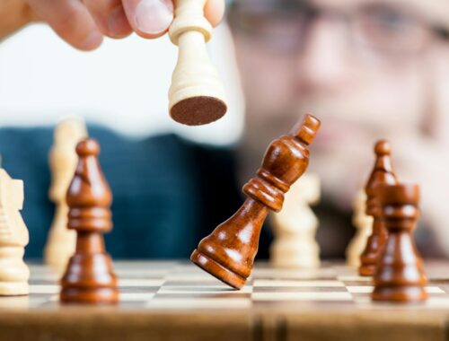 Close-up of a chess game with a focused player, emphasizing strategy and competition.